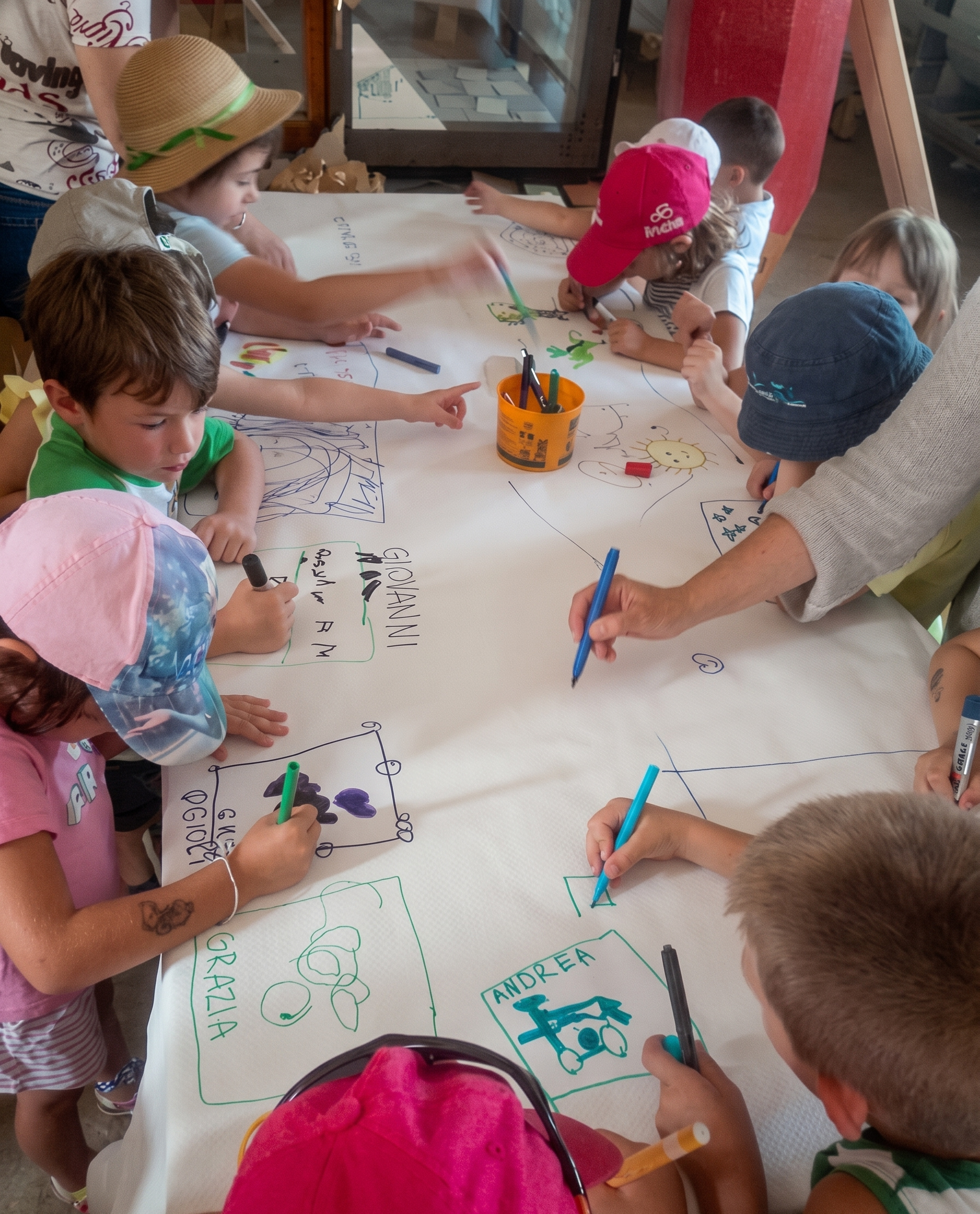 Bambini impegnati in un grande disegno collettivo durante un momento creativo del laboratorio.