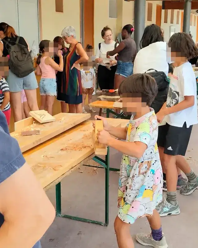Bambini lavorano in fila lungo un banco sotto il portico.