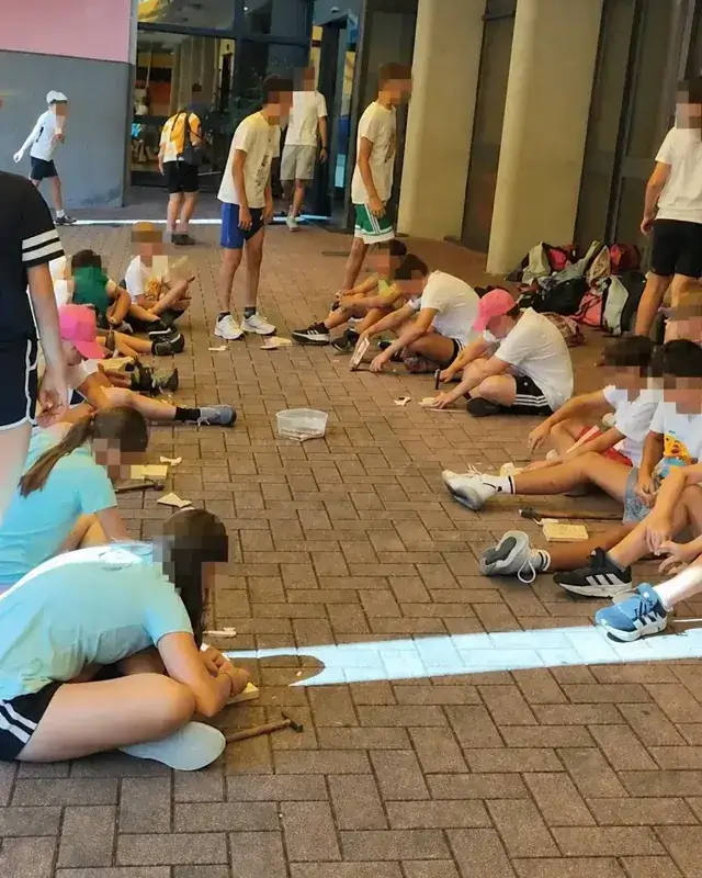 Ragazzi seduti a gruppi lavorano il legno nello spazio esterno del CRE.